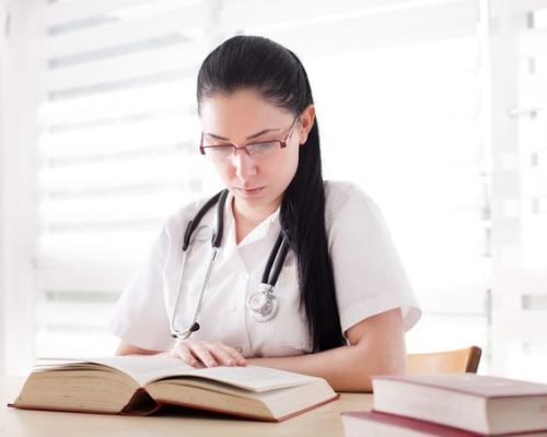 Young,Girl,,Student,Of,Medicine,Studying,And,Researching,Books,At